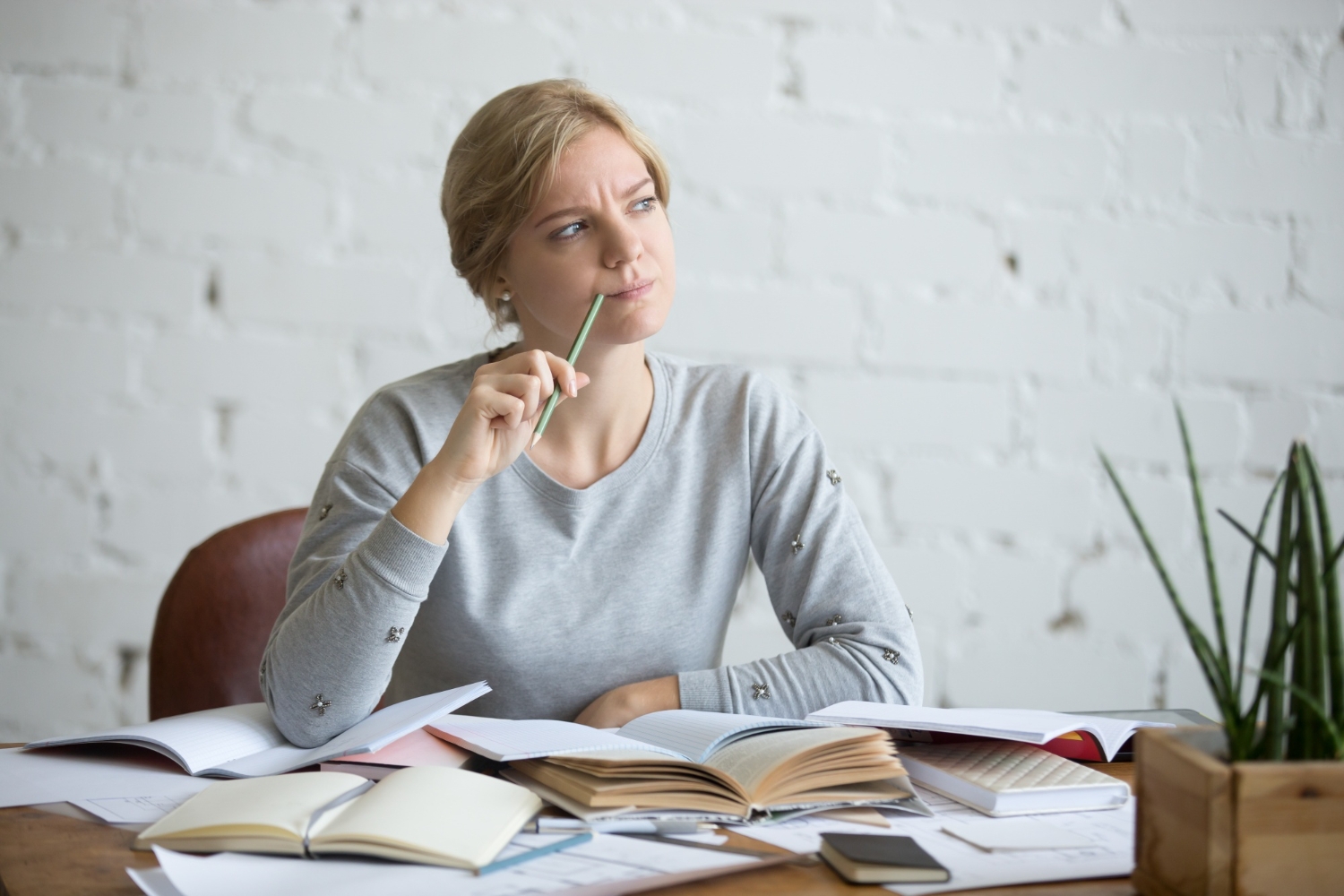 Woman thinking about work and psychotherapy surrounded with books